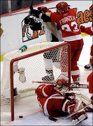 Red Wings goalie Chris Osgood can t stop a shot by Maxime Talbot, top, with 35 seconds left in regulation. It tied the game at 3.
