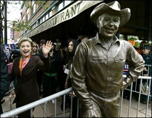 Sen. Hillary Clinton (D., N.Y.) passes a statue of Ronald Reagan as she emerges from Tally's Restaurant during a campaign event in Rapid City, S.D., that may be one of her last.