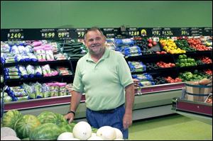 After serving his sentence for bribery, former city councilman Bob McCloskey stacks groceries in Toledo Food Market. As councilman, he said he helped at the store's grand opening.