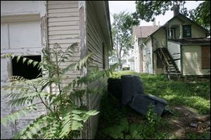 Neighbors say they are tired of looking at the peeling paint, broken windows, and siding at 505 St. Louis. The second-story window and door are not boarded up, which makes it easier for unwanted humans and vermin to get into the dwelling that is now owned by Neighborhood Housing Services.