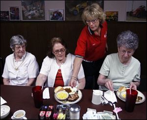 Joyce Gossard serves Kitty McFadden of McComb, Ohio, at the South Side Family Restaurant in Findlay. Ms. McFadden and her friends Alice Bowman, left, and Beverly Stein, right, both of Findlay, participate in a new dining program for seniors.