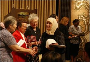 Kalthoum Mohamad Abdo, right, is greeted by, from left, Diane Mieczkowski, League of Women Voters; Catherine Blystone, American Legion; and Janet Mills, Daughters of the American Revolution.