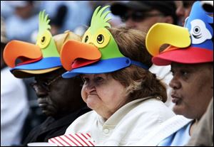 Jerry Bowie, Hazel Ruby, and Rita McCullew, from left, residents of Arbors at Toledo on Cherry Street, are decked out in appropriate headgear as they watch the Mud Hens take on the Syracuse Chiefs during Senior Day at Fifth Third Field downtown. 