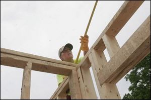 Tressa Duffin of Monroe measures a door frame in a house on Almyra Avenue in Monroe under construction in a Habitat for Humanity 'Blitz Build' on the city's east side.