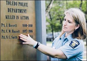 Toledo Police Officer Beth Cooley points out Officer C. W. Russell s listing on the police memorial.
She uncovered the error while working on the police department s 2007 annual report.