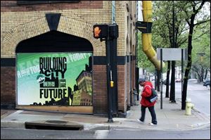 In Akron's historic district, a sign touts the city's rebuilding efforts. Government and private investors have put $1 billion into downtown Akron projects over the last 15 years.