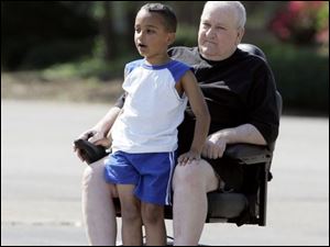 ROV ride24p  06/24/ 2008 The Blade/Dave Zapotosky Zachary Payne, 7, gets a ride from his grandfather Thomas Payne, along Olimphia Rd., near Dorr, St., in  Toledo, Ohio, Tuesday, morning, June 24, 2008.  The pair periodically go out for an approximately 2-mile long ride aboard the scooter.