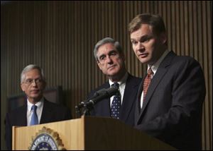 FBI Director Robert Mueller, center, with Ernie Allen, president and chief executive officer of the National Center for Missing and Exploited Children, left, and acting Assistant Attorney General Matt Friedrich, take part in a news conference at the FBI headquarters in Washington, Wednesday. 