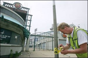 
Dan Williamson of Detroit puts caution tape on fencing outside the stadium.  Going to Tiger Stadium was going to a ballpark. Going to Comerica [Park] is like going to the mall,  he said.