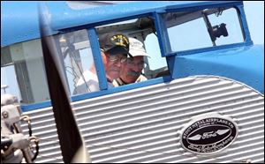 Maurice Hovius, left, a Tri-Motor restorer, and pilot Cody Welch prepare for takeoff at Erie-Ottawa Regional Airport. 