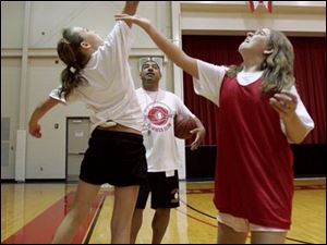 NBR basketballcamp03p  06/26/ 2008 The Blade/Dave Zapotosky Caption: Owens Community College women's basketball coach Mike Llanas watches as Allison Walsh, 10 of Oregon, left, and Samantha Sondergeld, 11, of Rossford, right, battle for a jump ball during the Express Girls "Summer Slam" Individual Basketball Camp at the college in Perrysburg Township, Ohio, Thursday, June 26, 2008.   Summary: This is for Neighbors Sports - wild art.The Owens Community College women's basketball program is holding a camp.  Females ages 8 to 15 are participating in the Express Girls "Summer Slam" Individual Basketball Camp.