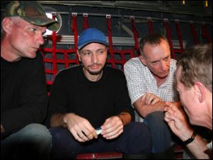 In this image released by the U.S. embassy in Colombia, U.S. contractors Keith Stansell, left, Marc Gonsalves, center, and Thomas Howes sit in an aircraft in an unknown location in Colombia after being rescued by Colombia's military from the Revolutionary Armed Forces of Colombia, or FARC on Wednesday.