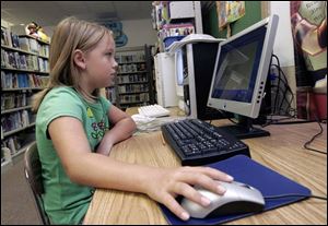 Addison Toth, 8, takes an accelerated reading test based on a book that she read during the elementary school's summer reading program. Addison will enter third grade in the fall.
