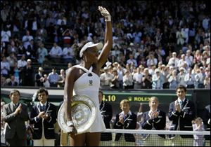 Venus Williams of the US holds her trophy and waves the crowd after winning the women's singles final against her sister Serena on the Centre Court at Wimbledon, Saturday.