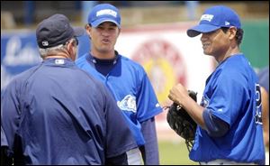 West Michigan Whitecaps players Wilton Garcia, center, and Mauricio Robles, right, talk with a roving hitting coach
before a recent game. Garcia and Robles participate in the Tigers  off-the-fi eld language assimiliation program.
