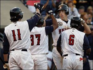 Mike Hessman is congratulated by Jeff Larish (11), Freddy Guzman (17), and Timo Perez after his fifth-inning home run.