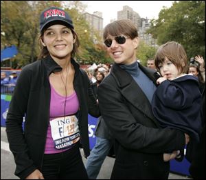 Katie Holmes joins her husband, Tom Cruise, and their daughter, Suri, after Holmes finished the New York City Marathon last November.