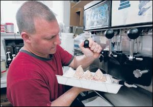 Greg Shubeta plants the ice cream in the dish for the
Banana Trough Sundae at Shubie s Ice Cream and Grill.