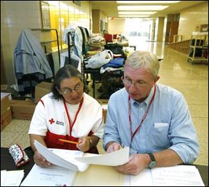 Red Cross volunteers Philomena Caratelli and Roger Heider, both of Toledo, set up at Bowsher High School.