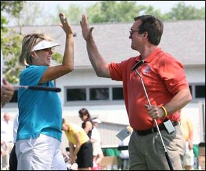 Tina Tombs and Jim Mihaly high-fi ve after Mihaly made a hole-in-one during the KeyBank Putting Pro-Am yesterday. Tombs had one LPGA title in 210 tournaments   the 1990 Farr.