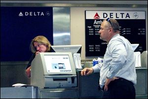 John Zajac of Perrysburg waits as a Delta agent at Toledo Express tries to help him change his daughter s flight from Italy.
