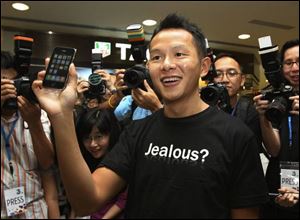 The first buyer in Hong Kong, Ho Kak-yin, holds his new iPhone during the first day of the release in Hong Kong on Friday.