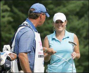Mallory Blackwelder, 21, a University of Kentucky student, is
congratulated by her father, Worth, who is also her caddie.

