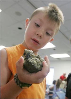 Spencer Sullivan of Port Clinton rolls a stone in his hand and gets a closer look at it during the hands-on history lesson.