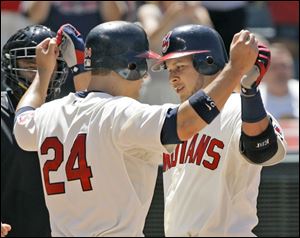 Cleveland s Grady Sizemore (24) and Jhonny Peralta
celebrate Peralta s home run against Tampa Bay.