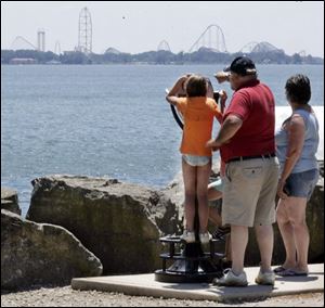 Olivia Matlack, 8, of Northwood takes a closer look at Cedar Point, just across Sandusky Bay from Marblehead. She was visiting the village last week with Mike and Julie Marshall of Millbury, Ohio.
