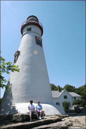 Barb Fehl and Bea LeJeune, both of Fremont, relax near the 1821 lighthouse, both a scenic lookout and historic site.
