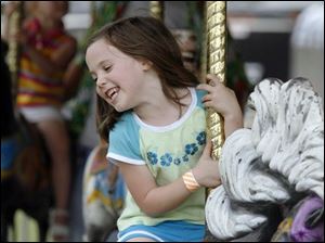 Slug: NBRW chicken17p  Date:  07/12/2008        The Blade/Andy Morrison       Location: Delta      Caption: Kylee Seidowsky, 6, Wauseon, enjoys the merry-go-round at the Delta Chicken Festival, Saturday, 07/12/2008.