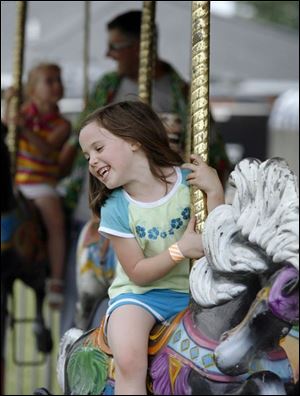 Slug: NBRW chicken17p  Date:  07/12/2008        The Blade/Andy Morrison       Location: Delta      Caption: Kylee Seidowsky, 6, Wauseon, enjoys the merry-go-round at the Delta Chicken Festival, Saturday, 07/12/2008.