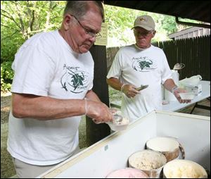Slug:  NBRE park17p            Date: 7/9/2008             The Blade/Amy E. Voigt       Location: Oregon, Ohio  CAPTION:  Volunteers Jerry Olsen, left, and Sam Gamble, right, from Oregon, scoop ice cream at the Summer Fest at Pearson Metropark on July 9, 2008.  The event included walking tours, games, face painting, boat rentals, and a cake and ice cream social.
