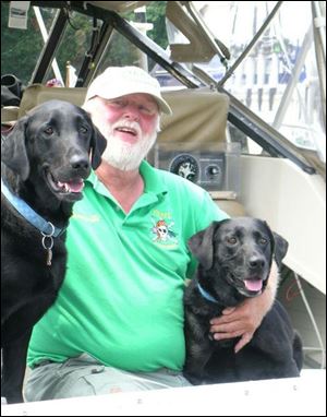 Ed LaBounty, skipper of the Pirate Queen, finds time to relax on his 31-foot craft with his Labrador retrievers, Jig and Lady.