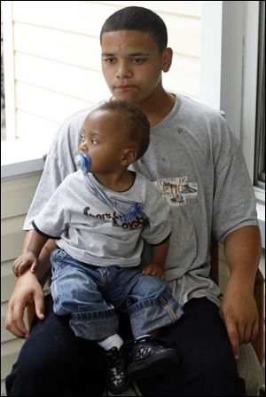 Tyler Kimble, 14, holding a nephew, says his brother Kenneth dreamed of playing basketball professionally.