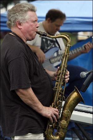 Saxophonist Gene Parker of the Gene Parker Quartet plays some blue notes during this year's blues festival downtown at Festival Park. In addition to music, the waterfront festival also features summer cuisine.