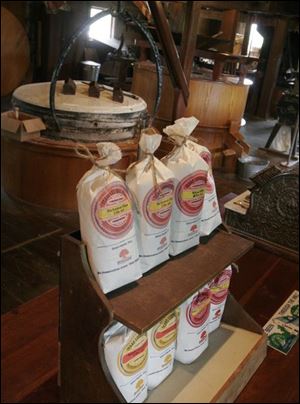 Bags of grain and the mill wheels used to grind them are displayed at the Isaac Ludwig Mill in Providence Metropark.