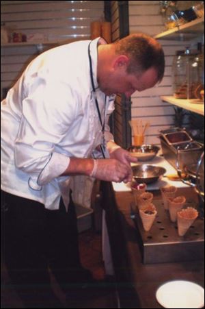 Executive Chef Nick Seccia, of the Henry Ford Museum in Dearborn, Mich., folds chocolate ganache and fruit into waffle cones.