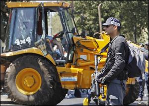 An Israeli security force officer stands guard next to a front-end loader as the Palestinian driver sits dead in his seat at the scene of an attack in Jerusalem on Tuesday.