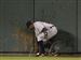 Detroit Tigers center fielder Curtis Granderson retrieves a ball from the mud after Kansas City Royals' Esteban German hit a triple during the ninth inning Tuesdayin Kansas City.