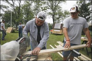 John Glesser, 15, of Curtice, Ohio, right, lends a hand to William Stroshine, 17, in sawing lumber for the gazebo the Eagle Scout candidate is constructing on the grounds of the Lutheran Homes Society. 
