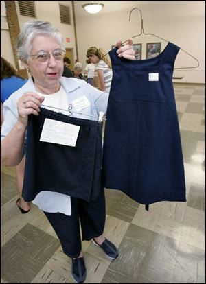 NBRW uniforms24p  07/17/ 2008 The Blade/Dave Zapotosky Caption: Ellen Bowers, coordinator of the uniform project at Sylvania United Church of Christ in Sylvania, Ohio, displays samples of the uniform skirts and jumpers volunteers from various churches are making, Thursday, July 17, 2008.  Volunteers were cutting out the pieces of the skirt and jumper kits, which will be sewn together by volunteers at a late date and distributed to needy Toledo Public School students.  Summary: Volunteers will be packaging kits of school uniforms for low income kids from 9 a.m. to noon July 17 and 24. The uniforms are distributed by Project Dignity.