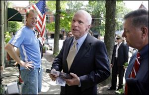 Presumed Republican presidential nominee John McCain holds a box of fudge presented to him during a visit to Columbus yesterday. At right is Sen. Lindsey Graham (R., S.C.).