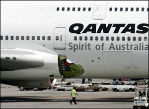 An airline mechanic walks past the damaged right wing fuselage of a Qantas Airways Boeing 747-400 passenger plane following an emergency landing on Friday in Manila, Philippines. (ASSOCIATED PRESS)
<br>
<img src=http://www.toledoblade.com/graphics/icons/video.gif> <b><font color=red>VIDEO</b></font color=red>: <a href=