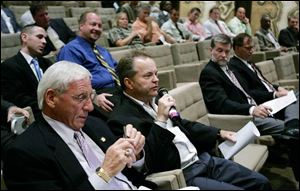 Developer Brian McMahon, with microphone, asks a question during a forum on Toledo Express Airport's future. At front left is Jerry Chabler, Ohio state racing commissioner and former port board member; on the other side of Mr. McMahon are Toledo City Council President Mark Sobczak and G. Opie Rollinson, vice chairman of the port board.
