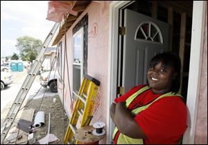Liz Long poses by her West Toledo home under construction by Habitat for Humanity on Waybridge Road off Bennett Road.