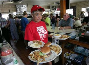 Pam Poland heads to a table. Schmucker's is charging 1948 prices on three items for dine-in customers. 