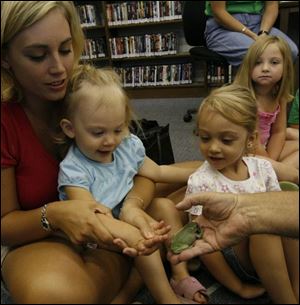 nbrn critters31p  7/24/2008  blade photo by herral long  Paul McCormack  with his classroom critters at the Vivian Branch library7   Allison Smith  holds her daughters Karlie Smith 20 mo hand  to pet the tree frog  as sisters Karlie 4 looks on