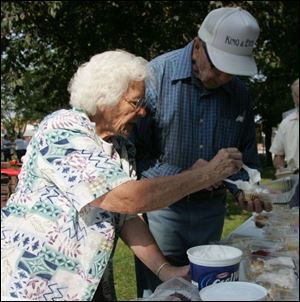 Marian Welling adds a dab of whipped topping to the peach pie of her brother-in-law, Robert Romaker of Perrysburg.